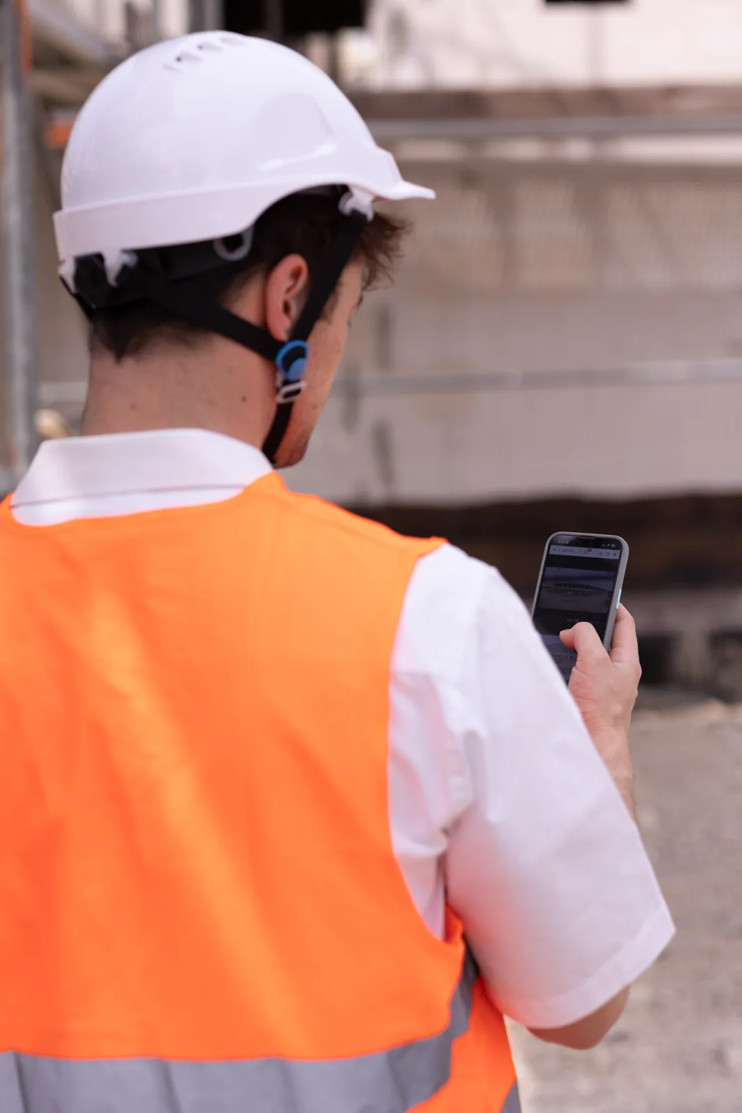 Site manager checking the BauTV+ app directly on the construction site