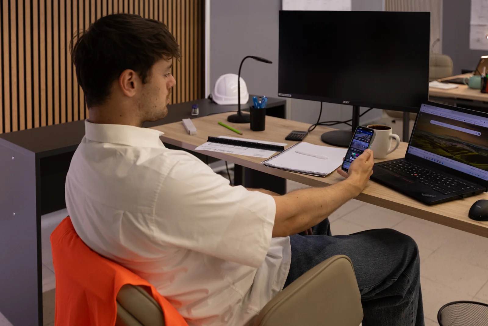 Site manager using the BauTV+ app at the office desk