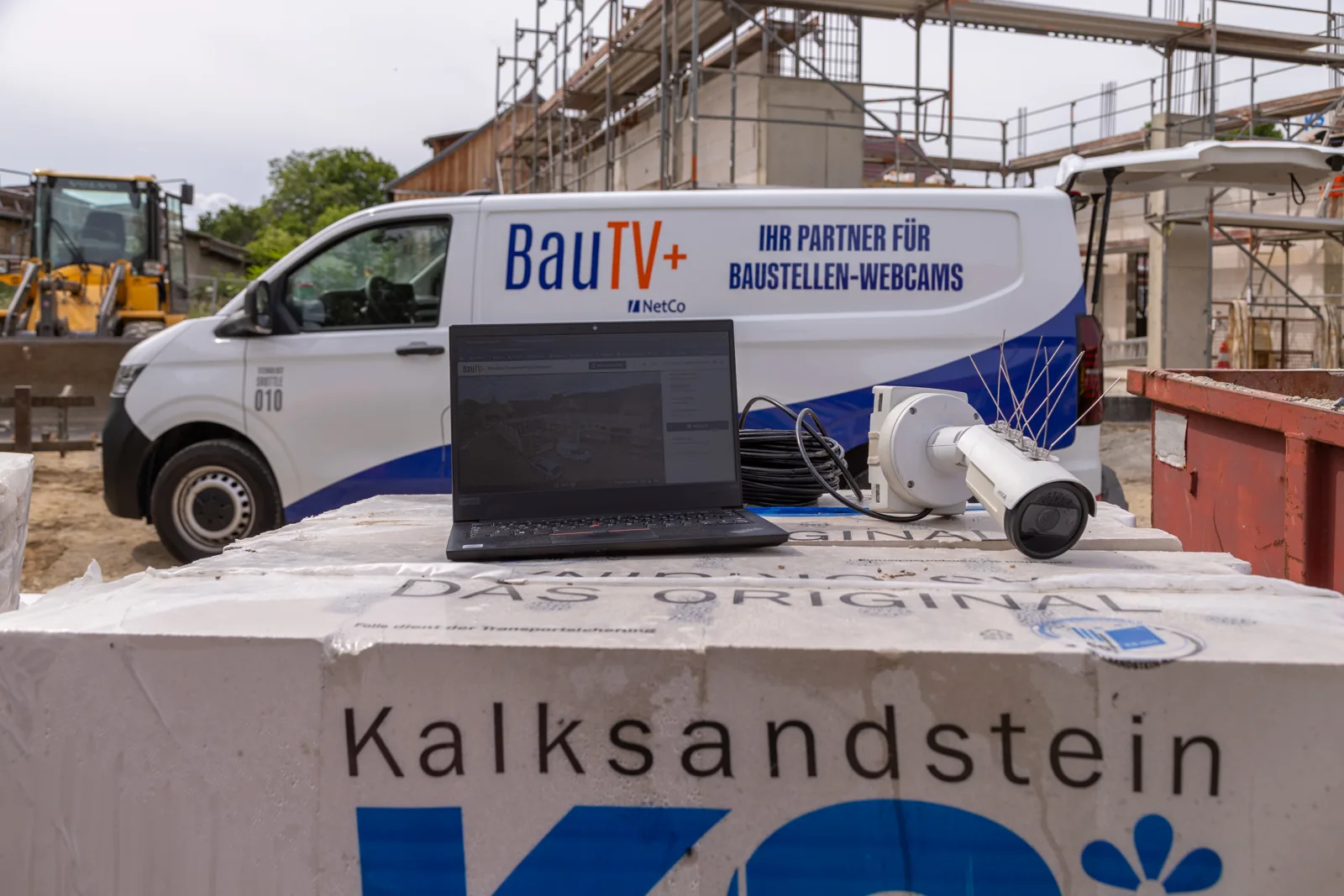 Construction camera and laptop with the portal in front of the BauTV+ service van