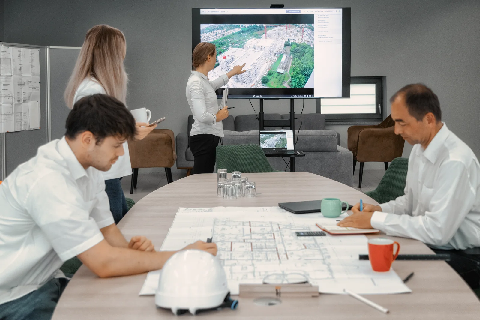 Site management discussing plans with the BauTV+ portal in view