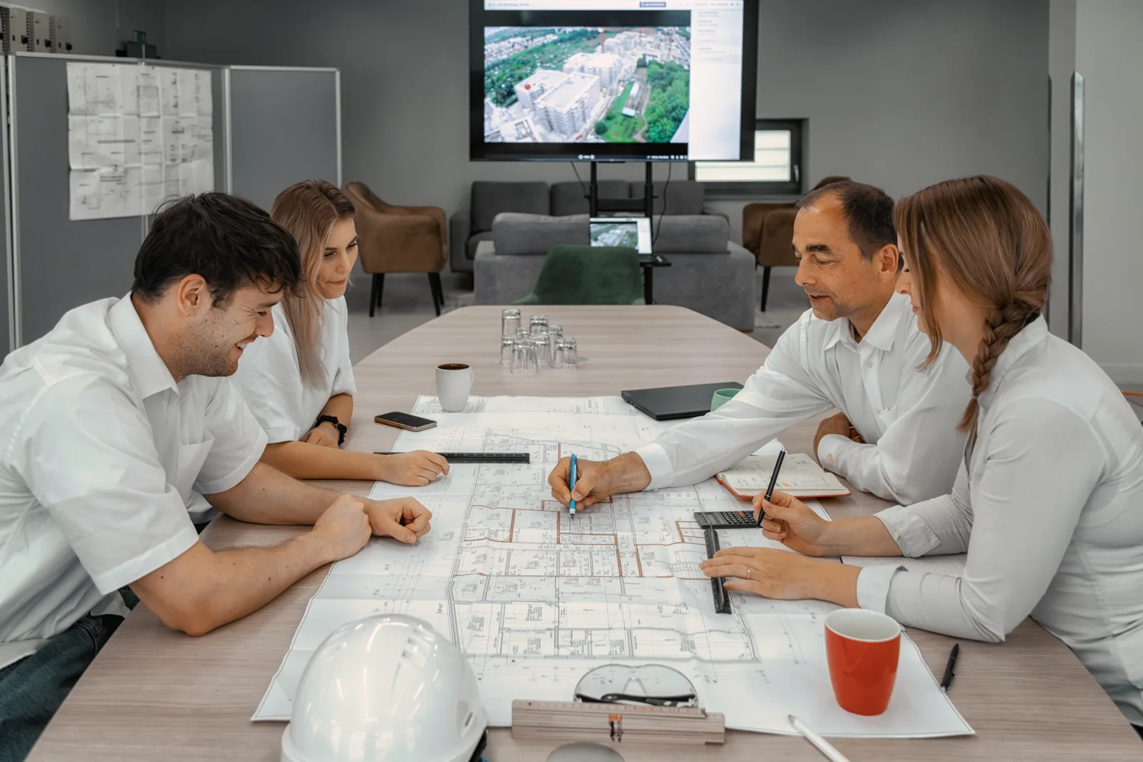 Project meeting with plans and helmet on the table