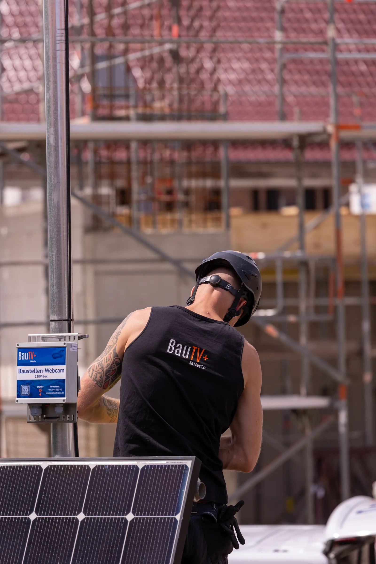 Technician aligning the construction camera on the mast — the field of view is set precisely to the construction field