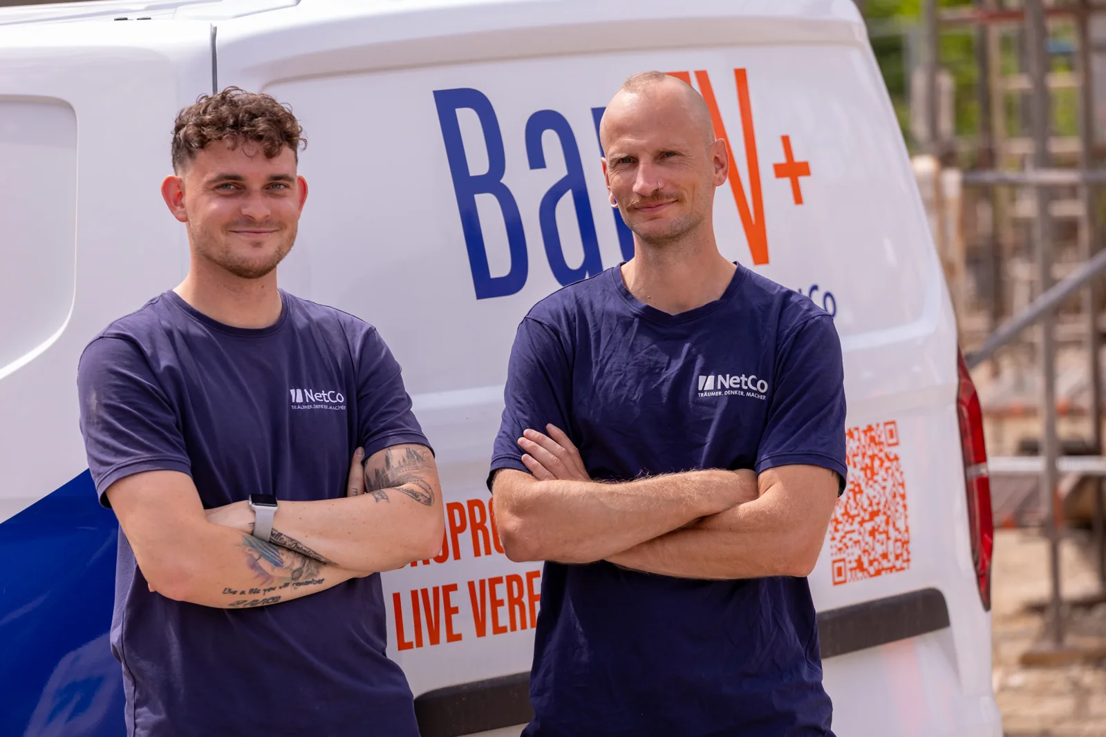 Two NetCo technicians in front of the service vehicle