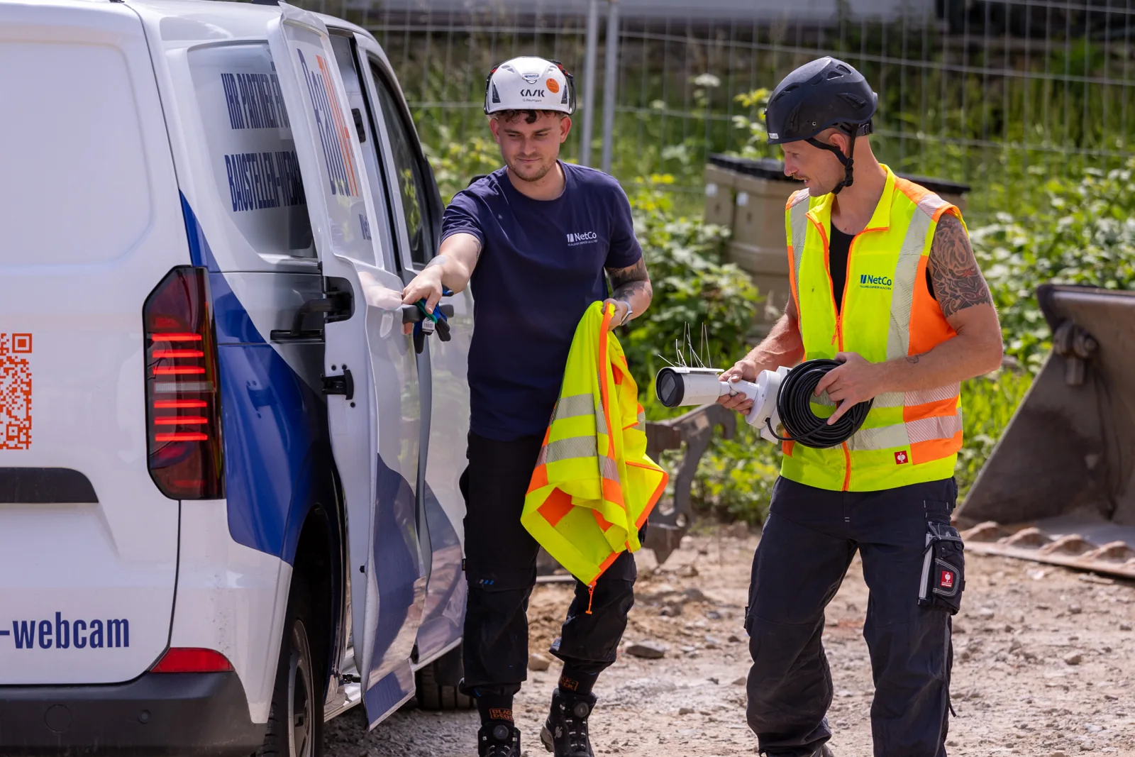 Two BauTV+ technicians unloading installation gear at the service van
